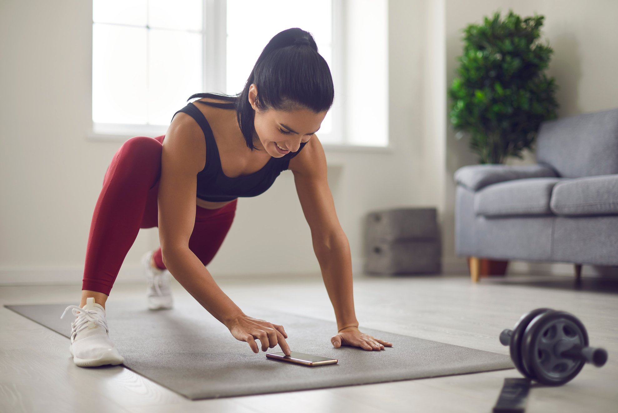 Woman Puts a Timer on Her Phone and Monitors the Progress of Her Workout on the Fitness App.